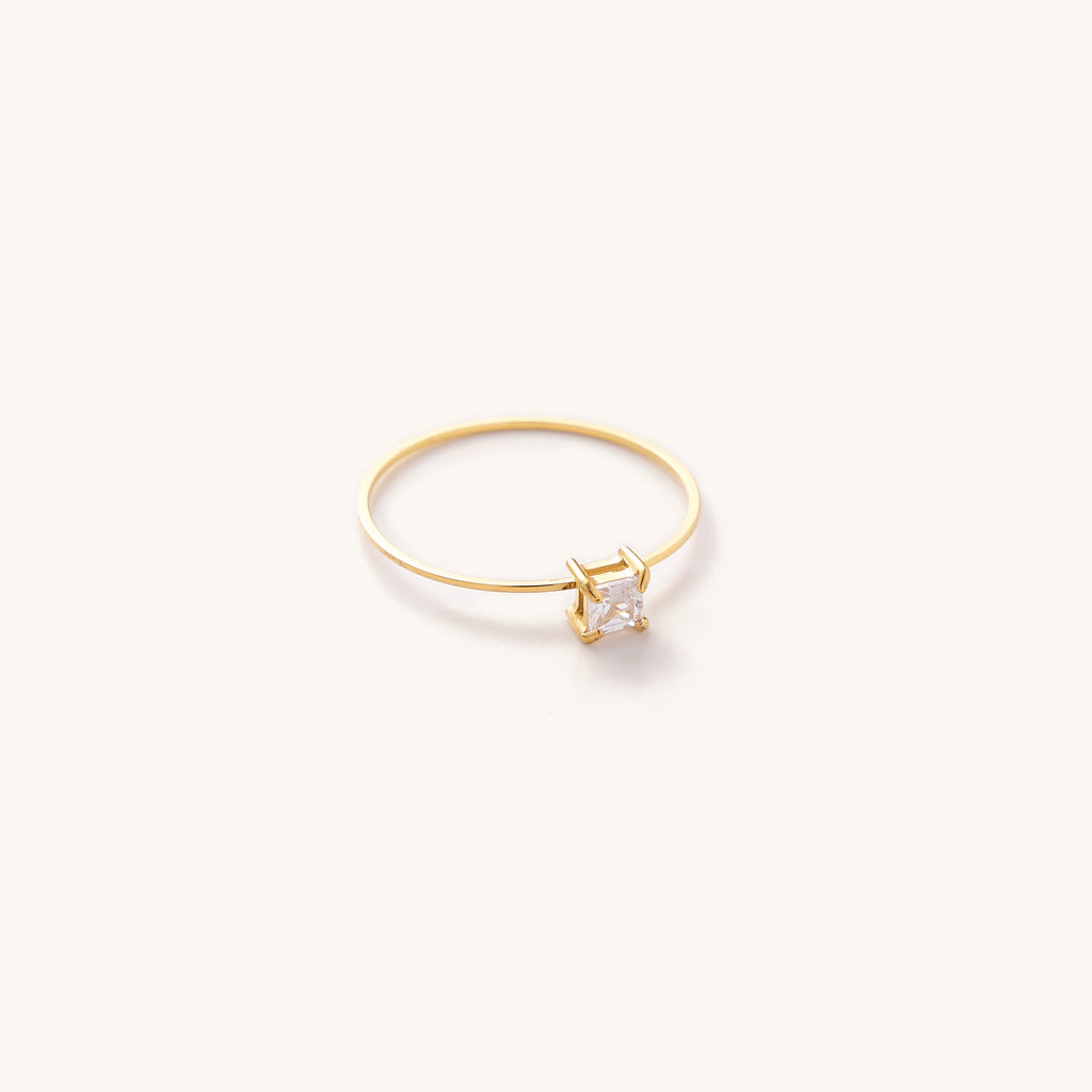 Thin gold band ring with a crystal square cut center